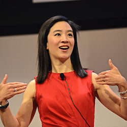 Photo of Dr. Hahrie Hahn giving a talk. Dr. Hahn is smiling, wearing a red dress, and gesturing emphatically.
