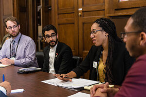 CCL volunteers lobby their member of Congress. From left to right sits a white man in a lavendar colored dress shirt, a middle eastern man in a suit and white dress shirt, a black woman with long braids and a black blazer, and a black man in a red shirt