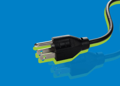 Cutout of a three-pronged electrical cord over a blue background, representing building electrification and energy efficiency