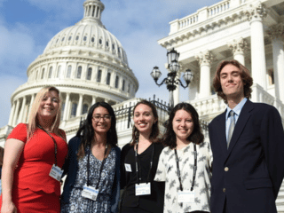 Five young people pose outside in front of the U.S. Captiol Building