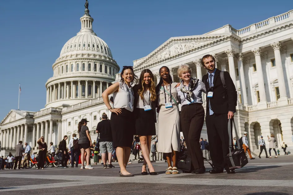 A group of climate change advocates stands in front of the Capitol building in Washington D.C.