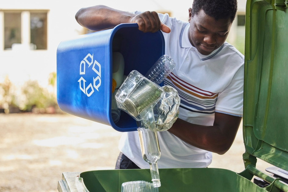 Man recycling glass, aluminum, and plastic.