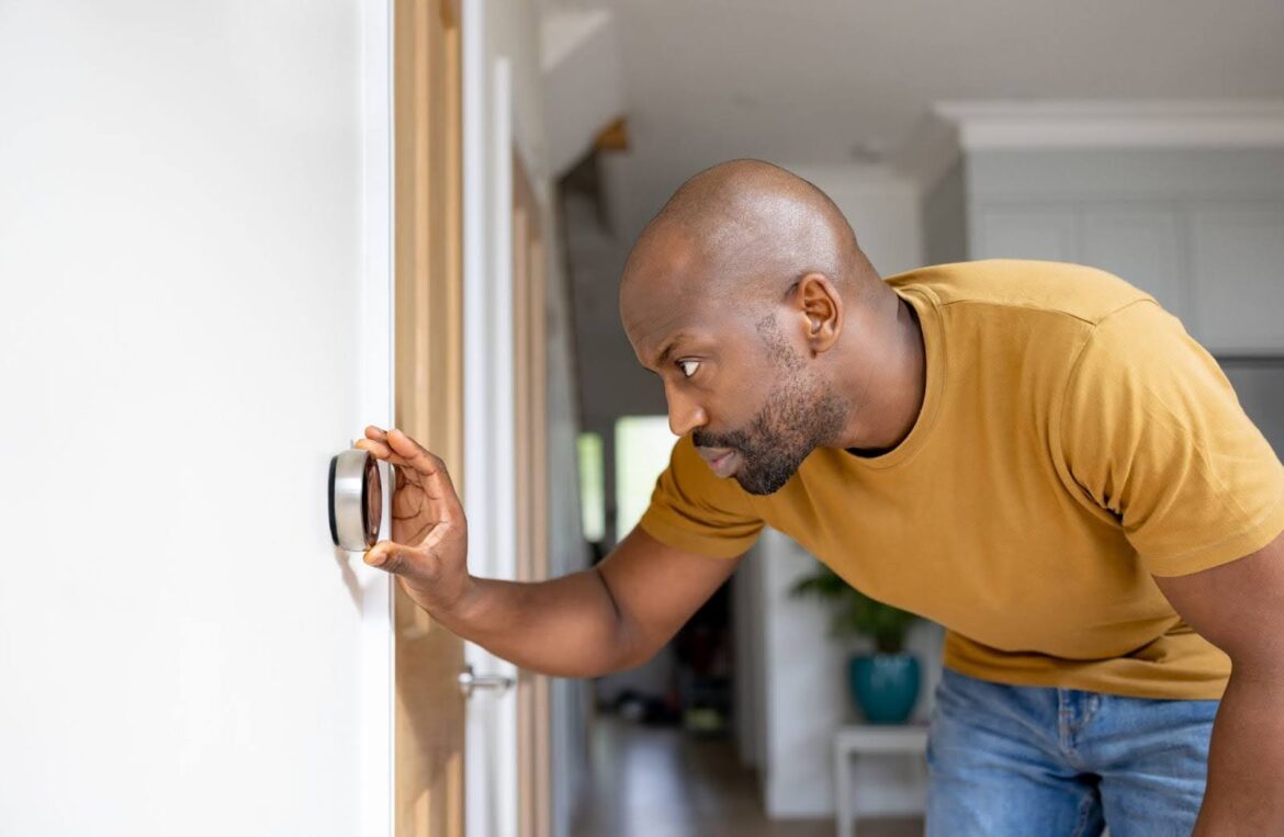 Man changing his thermostat