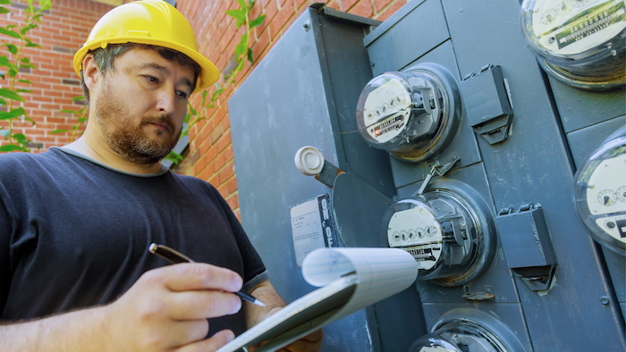 Electrical worker reading energy meters